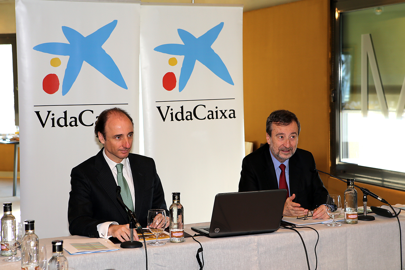 Rueda de prensa de VidaCaixa con dos ponentes en mesa con micrófonos. Rueda de prensa de VidaCaixa con dos ponentes en mesa con micrófonos.
